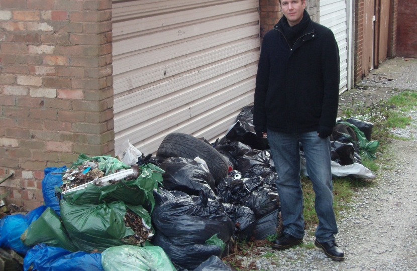 Cllr Matt Bennett next to uncollected rubbish bags on St Thomas Road