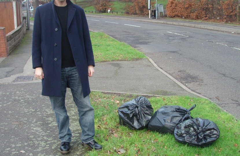 Cllr Matt Bennett next to uncollected rubbish bags on Gipsy Lane