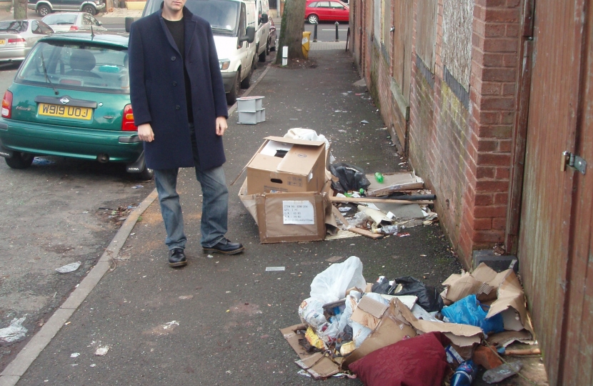Cllr Matt Bennett next to uncollected rubbish bags on Frances Road