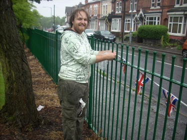 A wet Cllr Robert Alden putting up bunting before the event