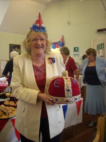 Local resident Wendy Bevan proudly holding the knitted crown she made
